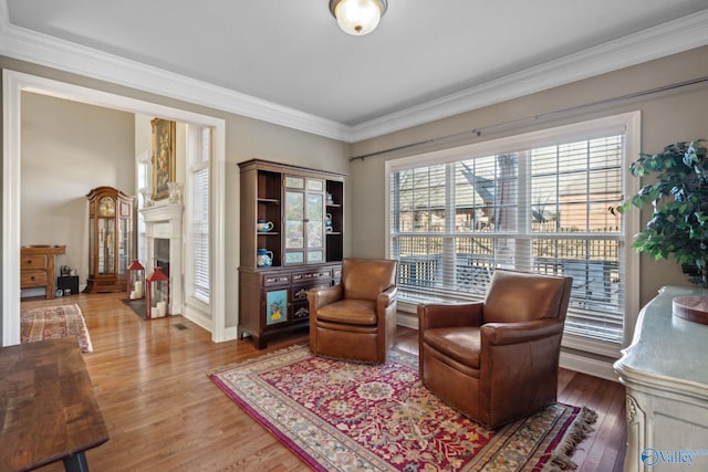 sitting room with ornamental molding and hardwood / wood-style flooring