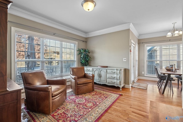 living area featuring hardwood / wood-style floors, ornamental molding, and a notable chandelier