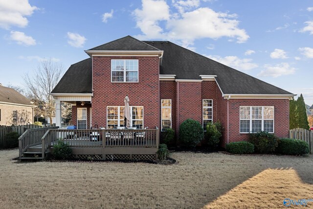 rear view of property with a wooden deck and a yard