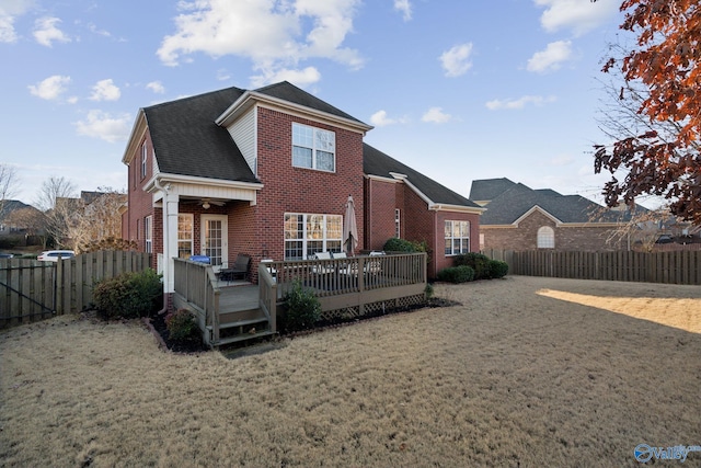 back of property with a yard, ceiling fan, and a wooden deck