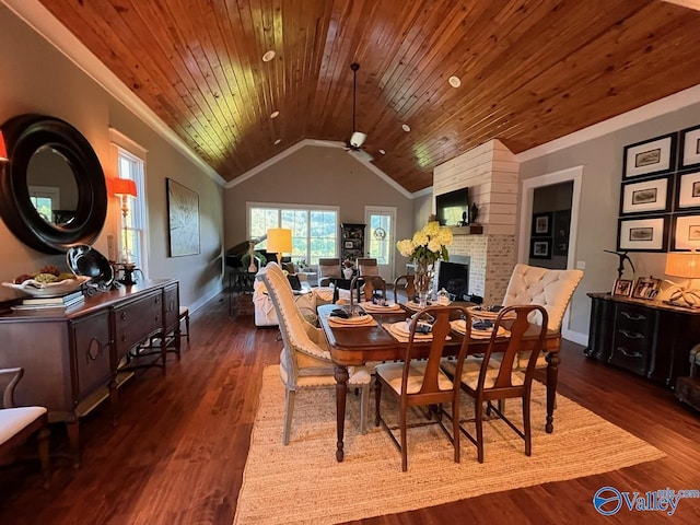 dining room with wood ceiling, vaulted ceiling, ceiling fan, dark hardwood / wood-style floors, and a fireplace