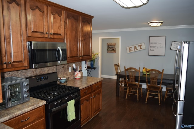 kitchen featuring ornamental molding, backsplash, stainless steel appliances, and dark hardwood / wood-style floors