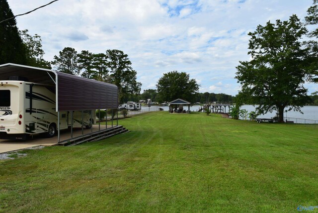 view of yard featuring a water view and a carport