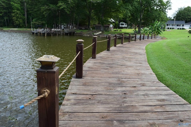 dock area with a water view and a lawn