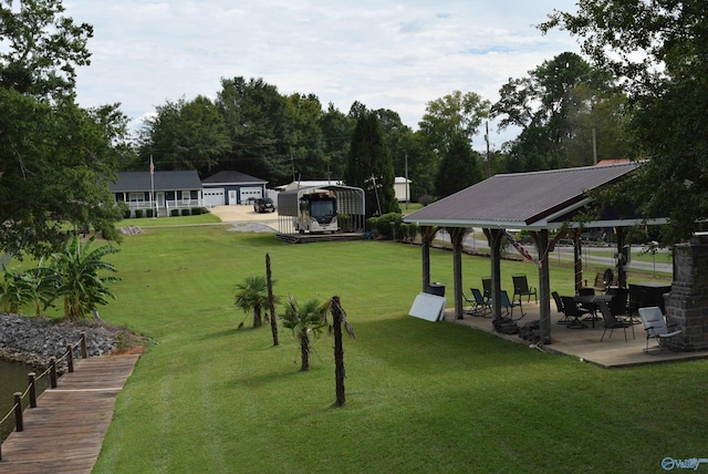 view of property's community featuring a patio area, a lawn, and a gazebo