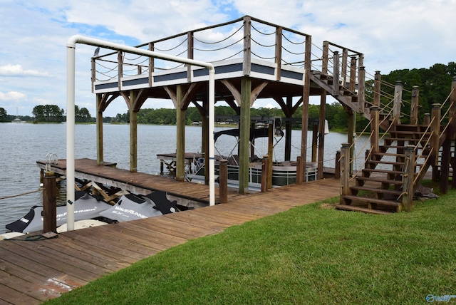 dock area with a lawn and a water view