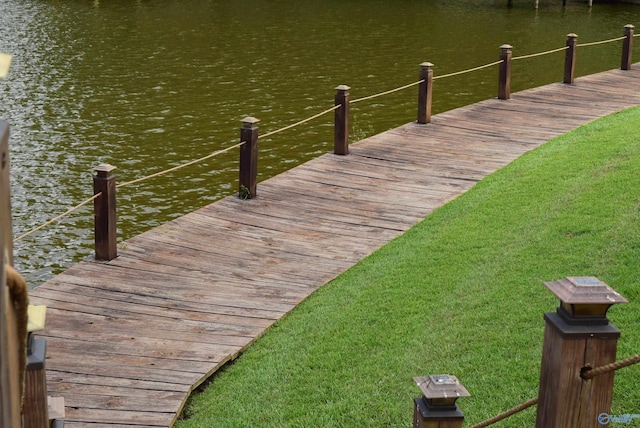 dock area featuring a water view and a yard