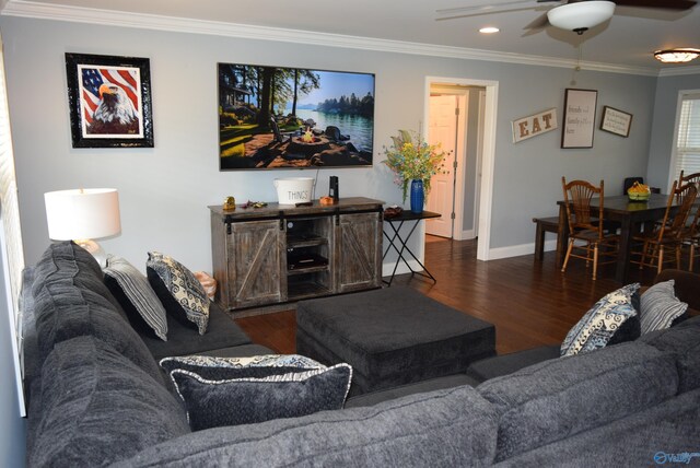 living room with dark wood-type flooring, ceiling fan, and crown molding