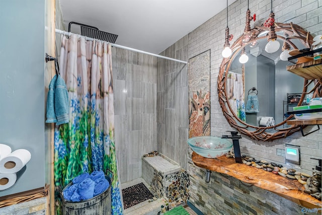 bathroom with brick wall, sink, and a shower with curtain