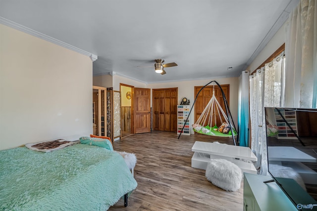 bedroom with crown molding, wood-type flooring, and ceiling fan