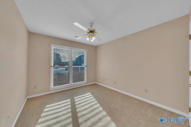 unfurnished room with light carpet, ceiling fan, a textured ceiling, and baseboards