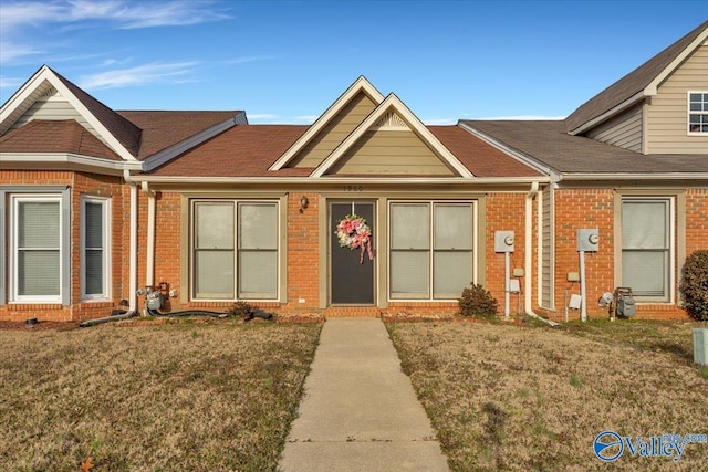 view of front facade featuring brick siding and a front yard