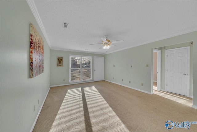 spare room featuring light carpet, baseboards, visible vents, and ornamental molding