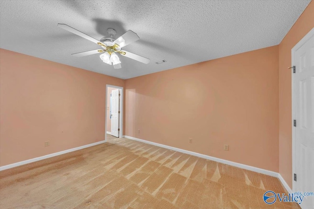 unfurnished room with light carpet, ceiling fan, baseboards, and a textured ceiling