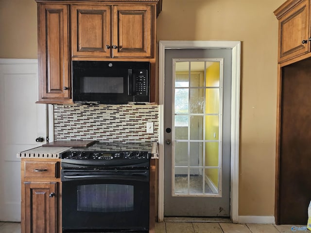 kitchen featuring black appliances, light tile patterned floors, and decorative backsplash