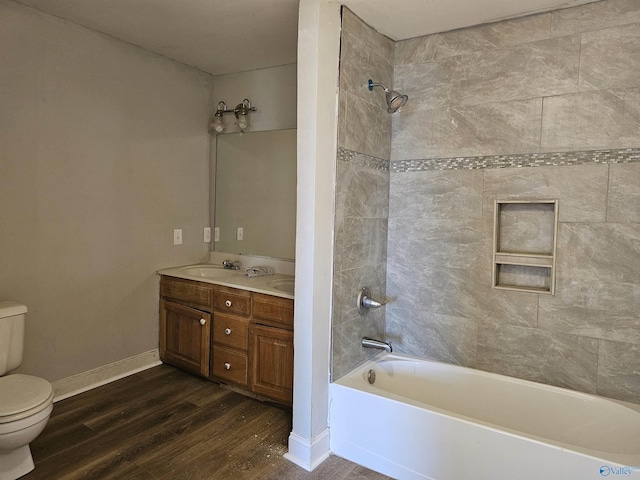 full bathroom with toilet, tiled shower / bath combo, wood-type flooring, and vanity