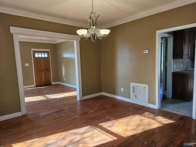 unfurnished dining area with light hardwood / wood-style floors, ornamental molding, and an inviting chandelier