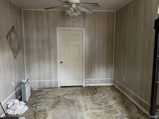 unfurnished room featuring ceiling fan and wooden walls