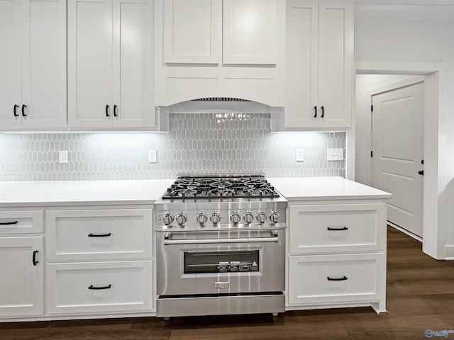 kitchen with white cabinets, high end range, dark wood-style flooring, light countertops, and backsplash