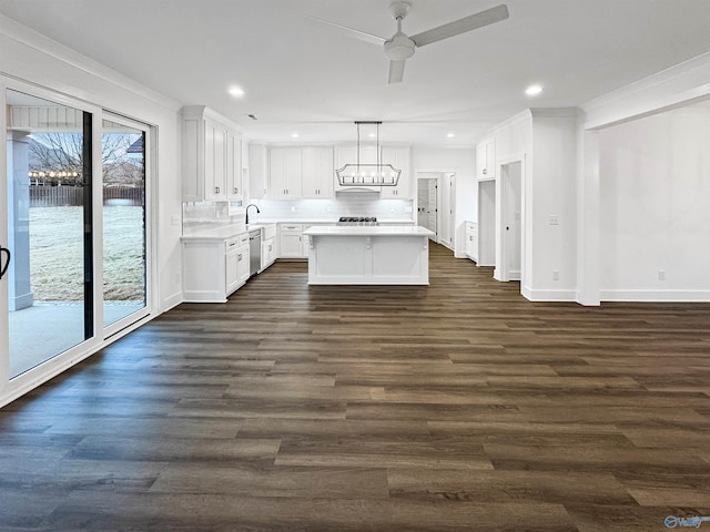 kitchen featuring a sink, white cabinetry, light countertops, stainless steel dishwasher, and dark wood finished floors