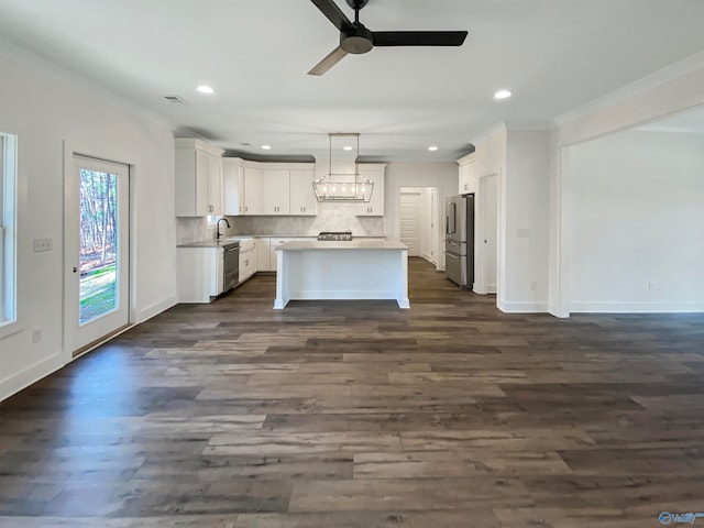 kitchen featuring white cabinets, dark wood-type flooring, hanging light fixtures, and stainless steel appliances