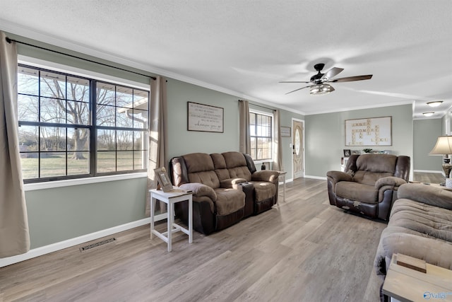 living room featuring a wealth of natural light, hardwood / wood-style floors, and ceiling fan