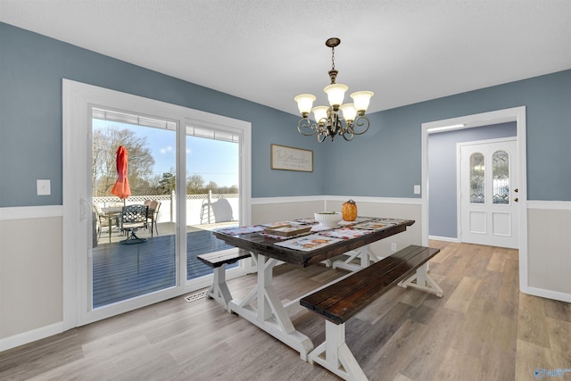 dining room featuring a chandelier, a textured ceiling, and hardwood / wood-style flooring