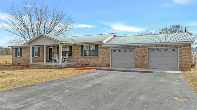 ranch-style home with covered porch, a garage, and a front lawn