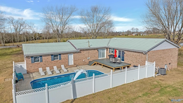 view of pool with central air condition unit, a lawn, and a deck