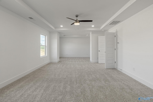 carpeted empty room featuring a raised ceiling and ceiling fan