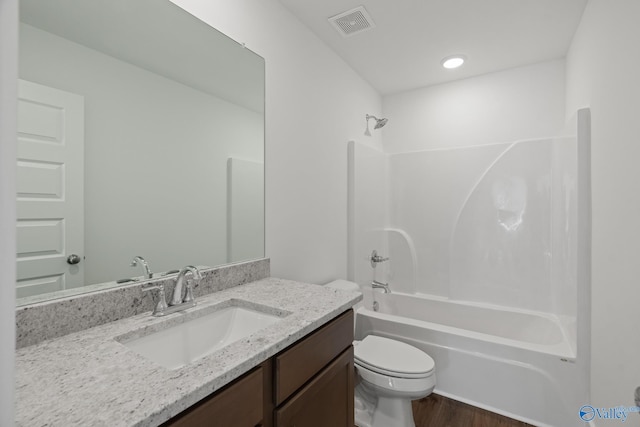 full bathroom with vanity, hardwood / wood-style flooring, tub / shower combination, and toilet