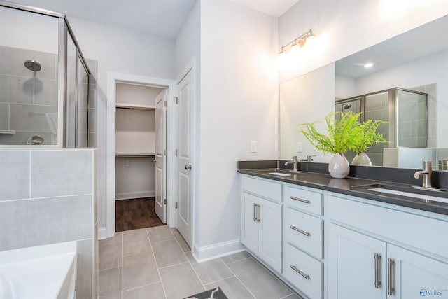 bathroom featuring a shower with door, vanity, and tile patterned floors