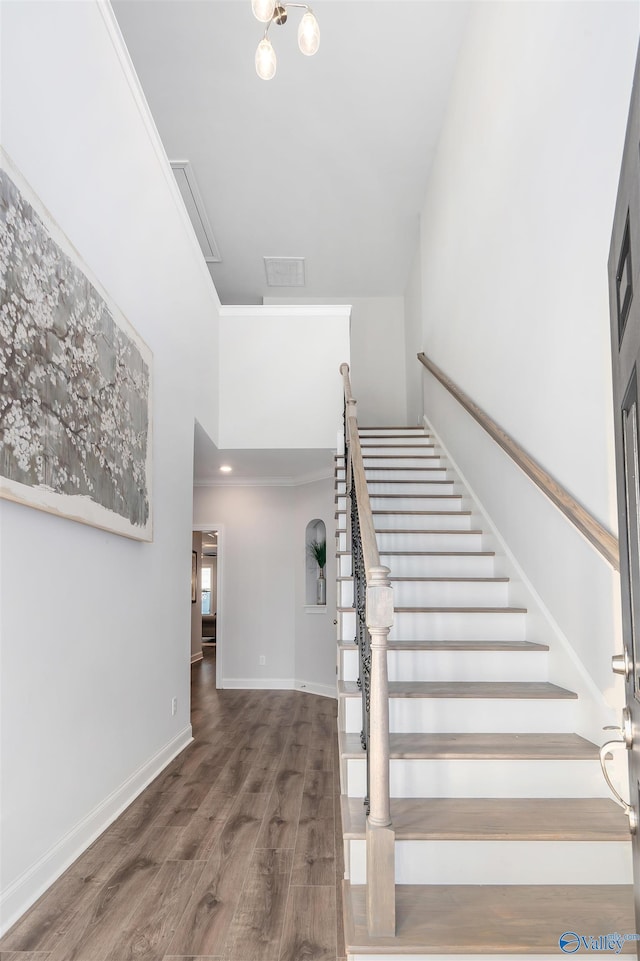 stairway featuring crown molding and hardwood / wood-style flooring