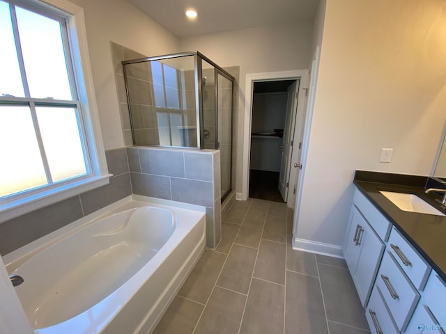 bathroom with tile patterned flooring, shower with separate bathtub, and vanity