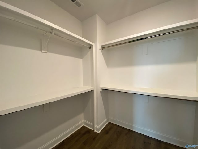 walk in closet with dark hardwood / wood-style floors