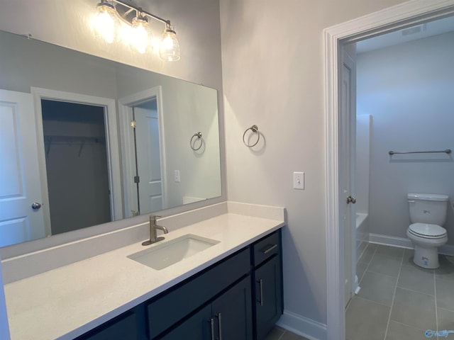 bathroom with a tub to relax in, vanity, toilet, and tile patterned flooring