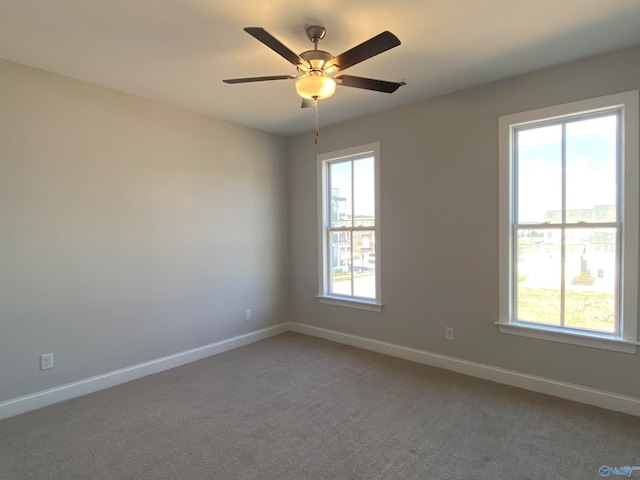 carpeted empty room featuring a wealth of natural light and ceiling fan