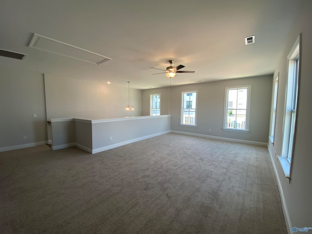 carpeted empty room with a wealth of natural light and ceiling fan