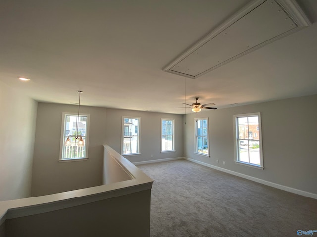 empty room with carpet floors and a notable chandelier