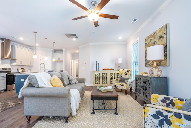 living room with crown molding, ceiling fan, and light wood-type flooring