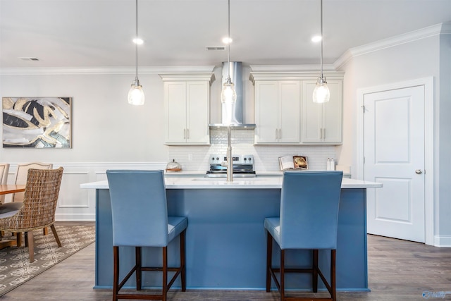 kitchen featuring pendant lighting, electric range, a center island with sink, and wall chimney range hood