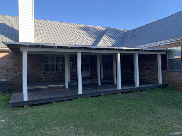 back of house featuring central air condition unit and a lawn