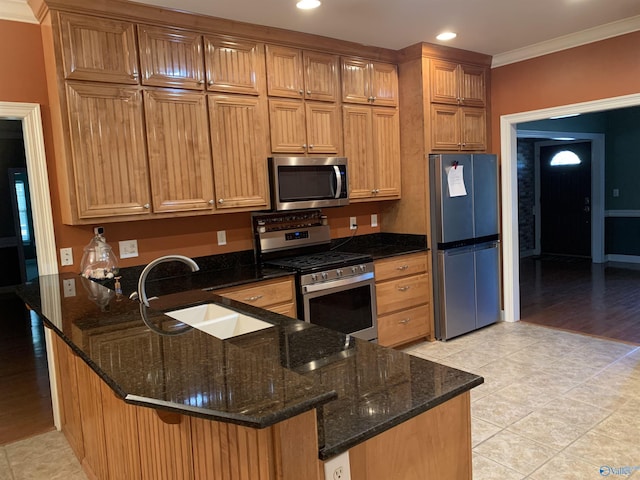 kitchen with dark stone counters, kitchen peninsula, sink, and stainless steel appliances