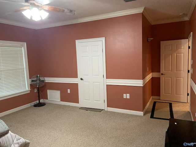 interior space with ceiling fan, light colored carpet, and ornamental molding