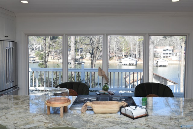 sunroom featuring a water view