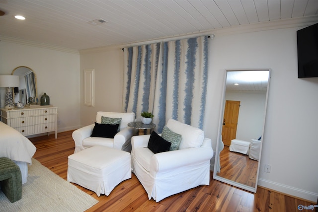 living area featuring hardwood / wood-style flooring and ornamental molding