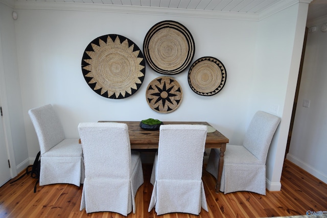 dining room with hardwood / wood-style flooring and crown molding