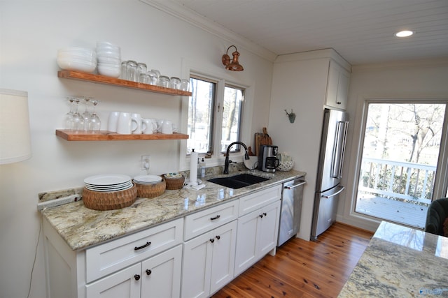 kitchen featuring light stone counters, appliances with stainless steel finishes, sink, and white cabinets