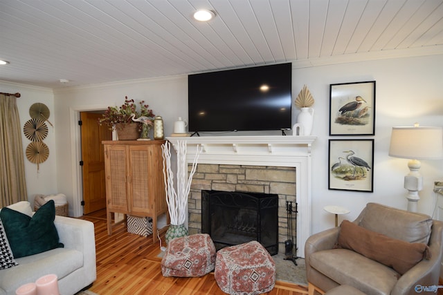 living room with crown molding, wood ceiling, a fireplace, and light hardwood / wood-style floors