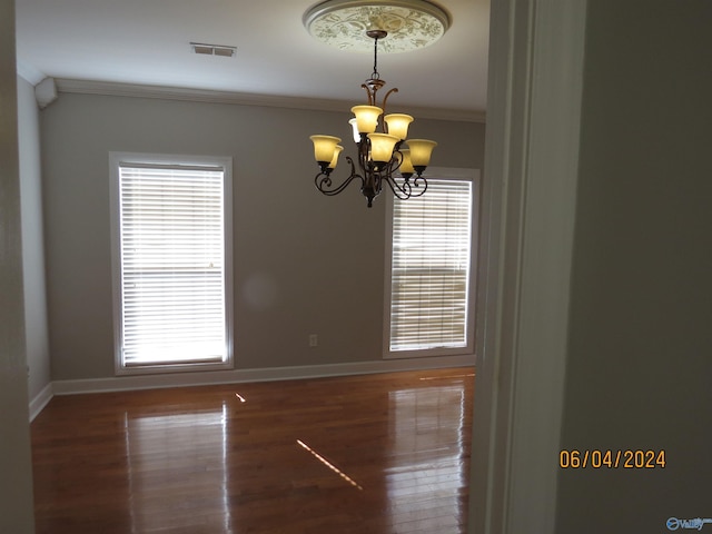 unfurnished room with ornamental molding, dark hardwood / wood-style floors, and a chandelier